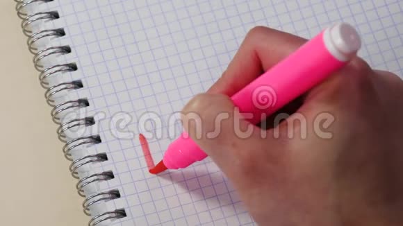 一个女人手在记事本上用粉红色的记号笔写着我爱你和小心脏这个词视频的预览图
