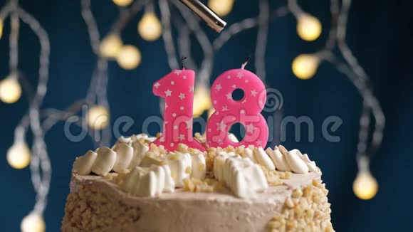 生日蛋糕有18个号码由较轻的粉红色蜡烛燃烧在蓝色的背景上蜡烛被点燃了慢动作视频的预览图