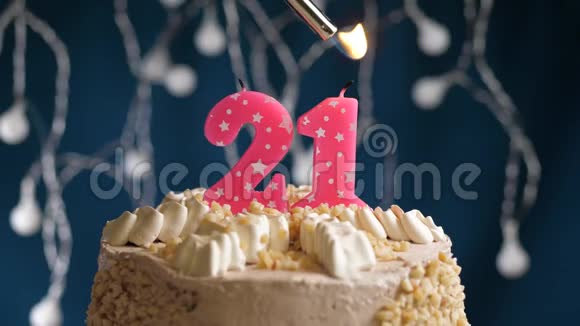 生日蛋糕21个号码燃烧由较轻的粉红色蜡烛在蓝色的背景蜡烛被点燃了慢动作视频的预览图