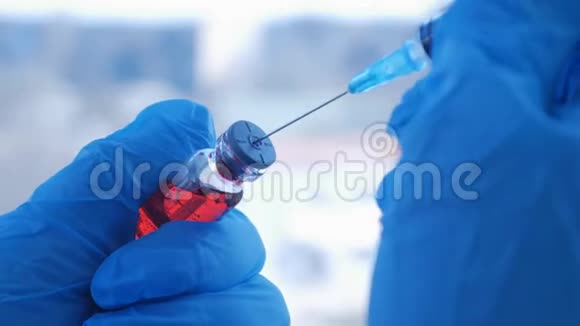 医生他的手在医院里拿着一个注射器和一个红色的疫苗瓶健康和医学概念视频的预览图