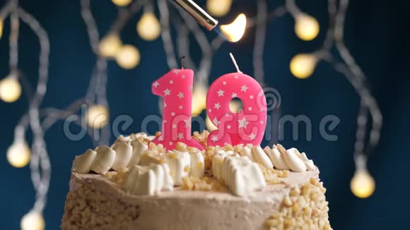 生日蛋糕有19个数字由较轻的粉红色蜡烛燃烧在蓝色的背景上蜡烛被点燃了慢动作视频的预览图