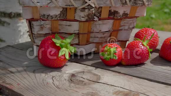户外木桌上放在篮子里的成熟草莓全景视频的预览图