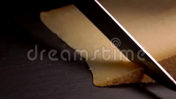 刀把硬干酪切成黑色表面的薄片视频的预览图