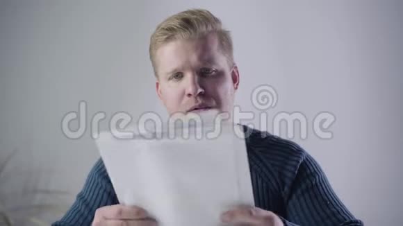 一个不满意的白人男人的特写看着文件把它们扔掉惹人厌的商人视频的预览图