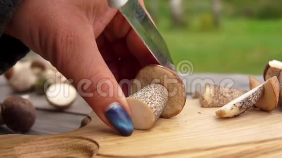 靠近一只雌性的手在木板上切一只刚采摘的蘑菇视频的预览图
