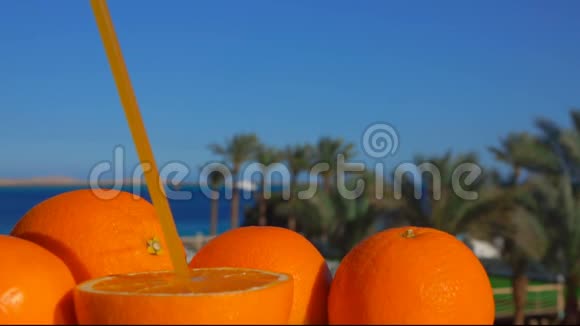美味的橙汁是用塑料吸管从减半的橘子里流出来的视频的预览图