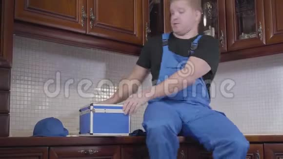 一幅快乐的白种人红头发男人坐在厨房里拿着热饮料脱掉杯子和上网的画像视频的预览图