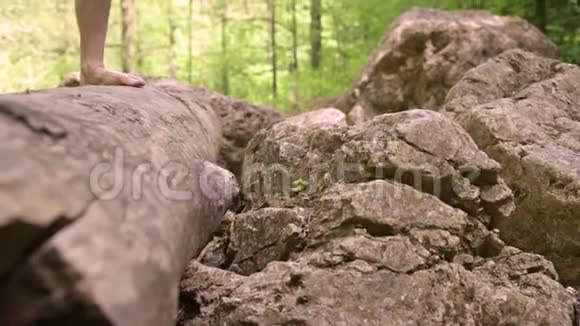特写镜头一个男人的腿旅行者光着脚在岩石路上爬河视频的预览图