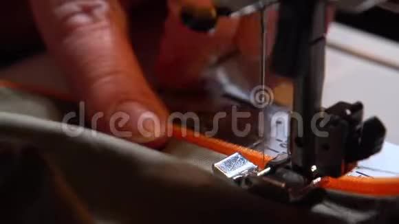 女人在缝纫机上缝橙色拉链视频的预览图
