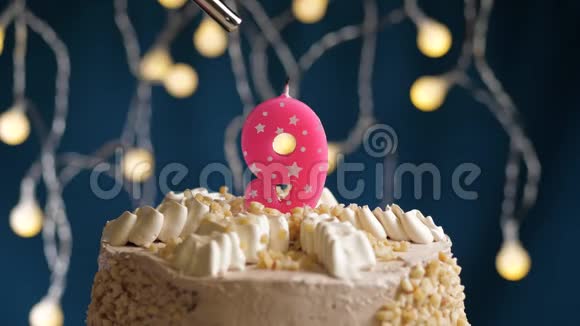 生日蛋糕9个数字燃烧由较轻的粉红色蜡烛在蓝色的背景蜡烛被点燃了慢动作视频的预览图