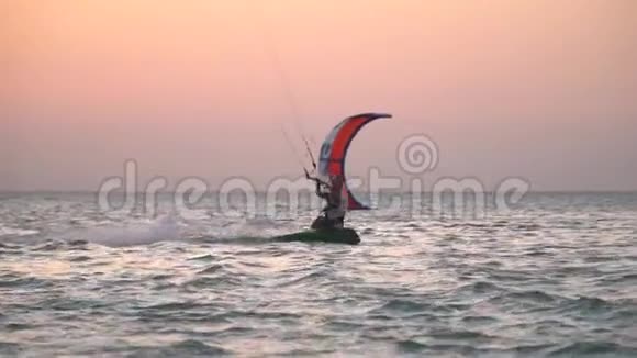 年轻女子在海上进行风筝冲浪滑翔身后有巨大的石油钻井平台视频的预览图