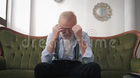 抑郁一个留着胡须和视力眼镜的老养老金领取者由于生活困难而痛苦和悲伤视频的预览图