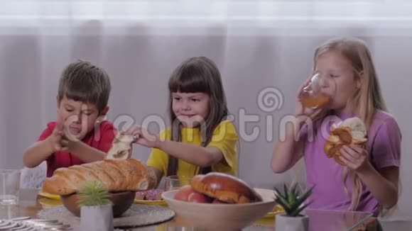 孩子们吃东西和孩子们的朋友愉快地在一起吃下午点心吃点心喝点果汁视频的预览图