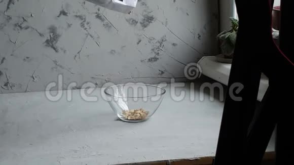 透明碗里的生燕麦片用来煮粥健康食品灰色背景视频的预览图