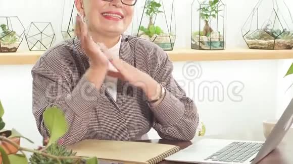 自信和愉快的白种人成熟女商人坐在办公室视频的预览图