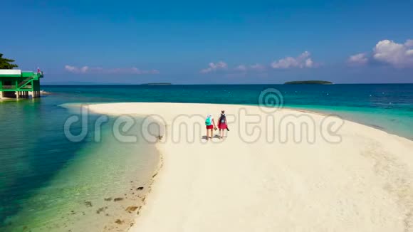 女游客漫步在热带海滩上完美的白沙滩从上面看视频的预览图