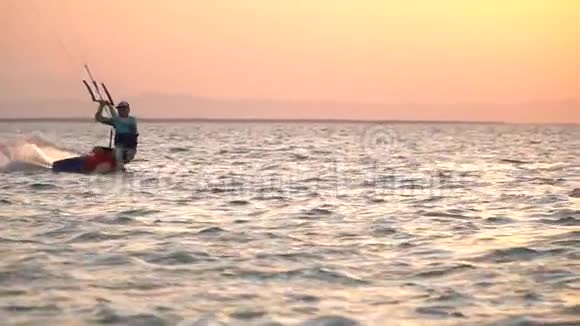 风筝冲浪者表演的空中技巧落在水里五彩缤纷的天空视频的预览图