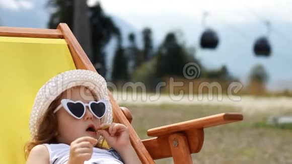 旅游女婴坐在缆车附近的躺椅上滑雪电梯的电缆方式供人们运输视频的预览图