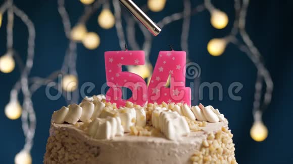 生日蛋糕54个数字燃烧由较轻的粉红色蜡烛在蓝色的背面蜡烛被点燃了慢动作视频的预览图