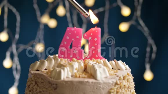 生日蛋糕41个数字燃烧由较轻的粉红色蜡烛在蓝色的背面蜡烛被点燃了慢动作视频的预览图
