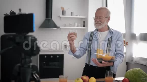 食品博客作者年长的有影响力的人带眼镜的视力和胡须写关于健康产品的博客并删除视频的预览图