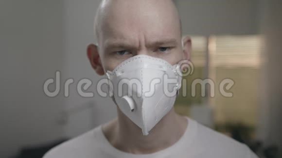 穿着t恤和面具的男人看着摄像机咳嗽视频的预览图