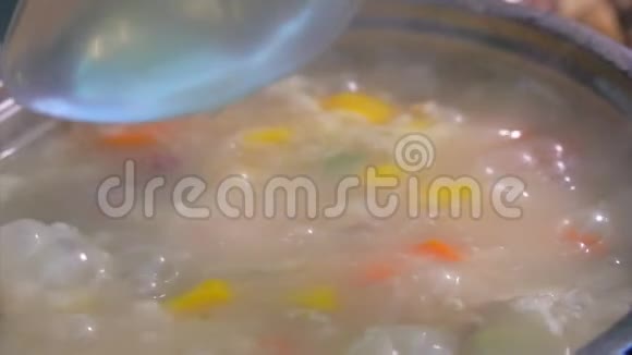 一个勺子把煮好的蘑菇汤和蔬菜混合在一起视频的预览图