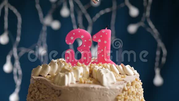 生日蛋糕有31个数字由较轻的粉红色蜡烛燃烧在蓝色的背景上蜡烛被点燃了慢动作视频的预览图