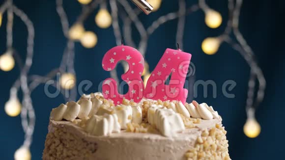 生日蛋糕34个数字燃烧由较轻的粉红色蜡烛在蓝色的背面蜡烛被点燃了慢动作视频的预览图