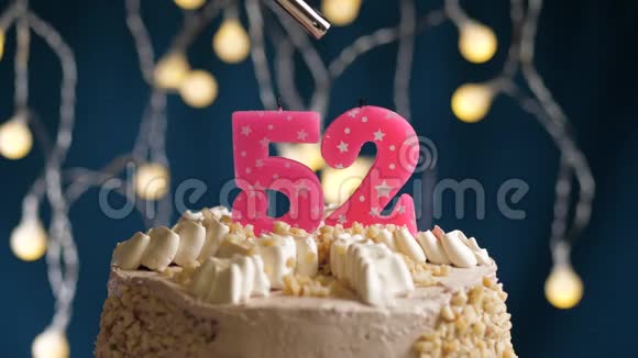 生日蛋糕52个号码燃烧由较轻的粉红色蜡烛在蓝色的背景蜡烛被点燃了慢动作视频的预览图