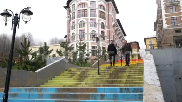 成功的商人在雨天走下楼梯靠近美丽的历史建筑和秋天的森林股票视频的预览图