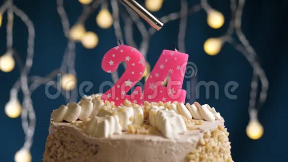 生日蛋糕24个数字燃烧由较轻的粉红色蜡烛在蓝色的背景蜡烛被点燃了慢动作视频的预览图