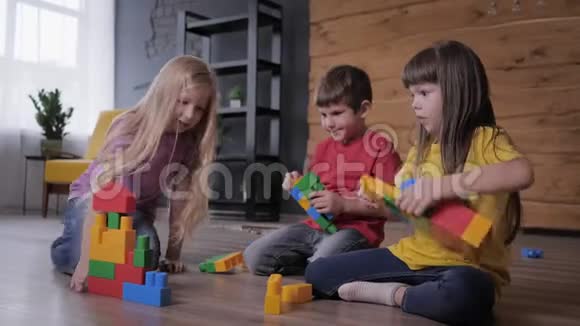 教育游戏友好的孩子玩在五颜六色的建设者和建立不寻常的玩具从细节视频的预览图