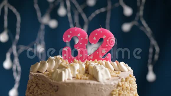 生日蛋糕32个数字燃烧由较轻的粉红色蜡烛在蓝色的背面蜡烛被点燃了慢动作视频的预览图