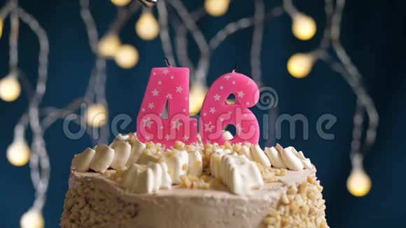 生日蛋糕46个数字燃烧由较轻的粉红色蜡烛在蓝色的背景上蜡烛被点燃了慢动作视频的预览图