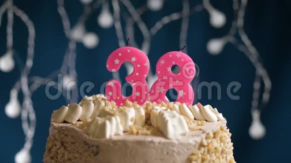 生日蛋糕有38个数字由较轻的粉红色蜡烛燃烧在蓝色的背景上蜡烛被点燃了慢动作视频的预览图