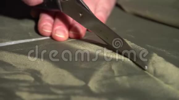 特写的女人用剪刀她的手把那部分从布料上剪下来视频的预览图