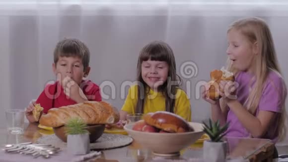在甜蜜的餐桌上庆祝孩子们的聚会后美丽的孩子们喜欢吃甜面包视频的预览图