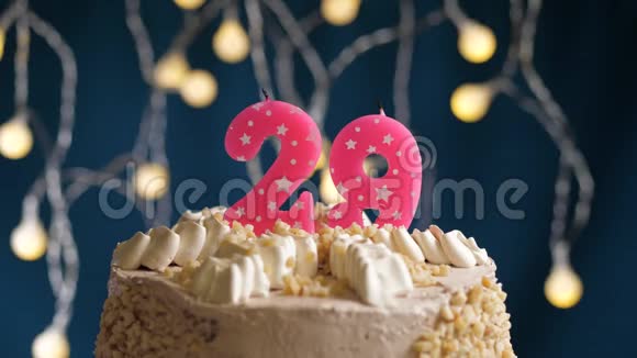 生日蛋糕29号由较轻的粉红色蜡烛燃烧在蓝色的背景上蜡烛被点燃了慢动作视频的预览图