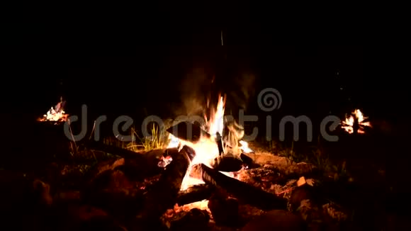 黑暗中三堆篝火燃烧火花从火中飞出来夏季低键特写视频的预览图