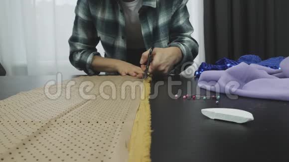 女士裁剪面料与剪刀在裁缝工作室肥皂片安全别针躺在桌子上把剪刀剪下布料CC视频的预览图