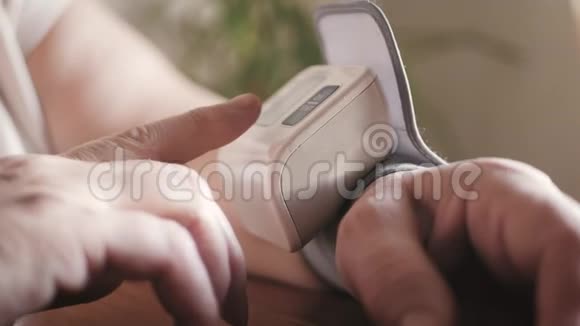 用手指按压数字血压计对自测血压进行特写妇女健康检查视频的预览图