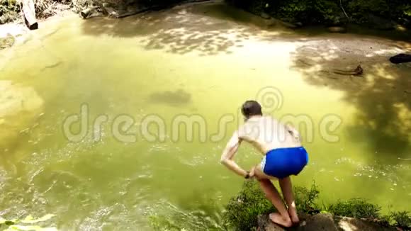 年轻的极端男子潜入天然池塘与淡水视频的预览图