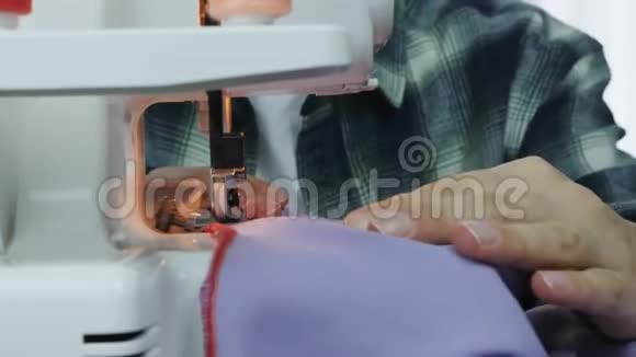 专业女裁缝在缝纫机上工作在裁缝工作室里用女性的手缝制布料创作和裁缝视频的预览图