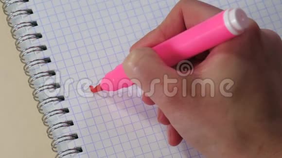 一个女人的手在记事本上用粉红色的记号笔写着谢谢这个词视频的预览图