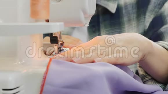 把女人的手指缝在缝纫机上缝纫机的细节女人的纺织物太多了工厂缝纫车间视频的预览图