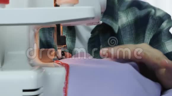 裁缝在车间用缝纫机缝制连衣裙超锁机的详细信息紧紧抓住女人双手工作和肌酸视频的预览图
