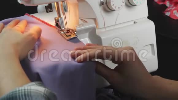 女性手在缝纫机上缝制织物的边缘把女人的手关上工作在超锁机器上创造和裁剪视频的预览图