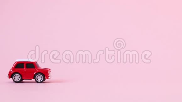 红色的孩子们玩具车骑在粉红色的背景上交付概念视频的预览图