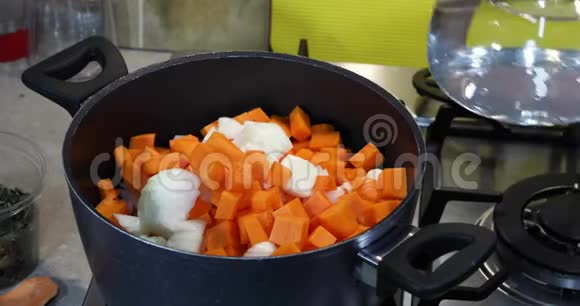一个女人把水倒进锅里里面放着一些原料放在煤气炉上做奶油汤健康饮食观念视频的预览图